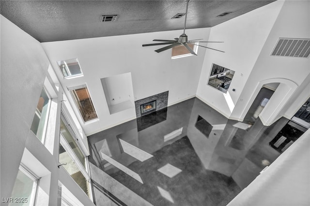 living room with high vaulted ceiling, a fireplace, and visible vents