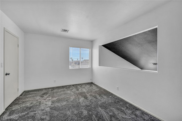 unfurnished room with a textured ceiling, carpet, and visible vents