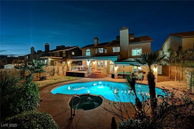 pool at twilight with a patio area, a fenced backyard, a pool with connected hot tub, and a deck