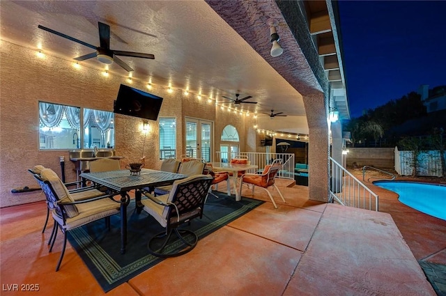 view of patio / terrace featuring outdoor dining area, fence, a ceiling fan, french doors, and a fenced in pool