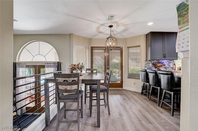 dining area with light wood-style flooring, recessed lighting, visible vents, baseboards, and an inviting chandelier