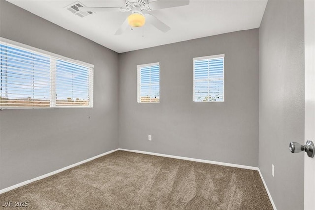 carpeted empty room featuring a ceiling fan, visible vents, and baseboards