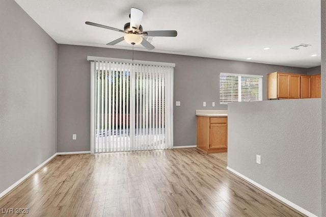 unfurnished room featuring a ceiling fan, baseboards, visible vents, and light wood finished floors