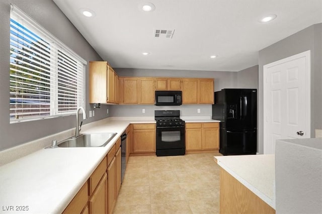 kitchen with black appliances, a sink, light countertops, and recessed lighting