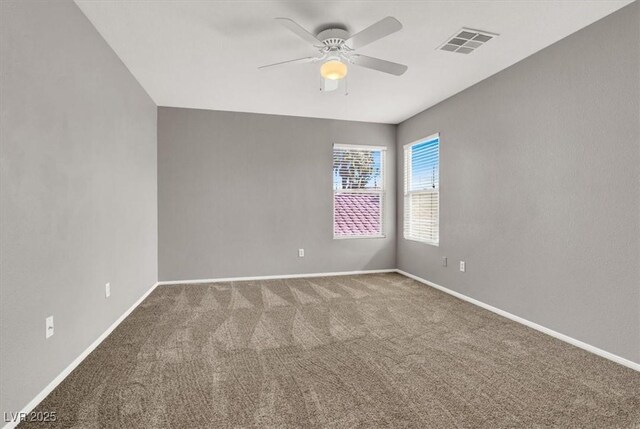 spare room with carpet floors, baseboards, visible vents, and ceiling fan