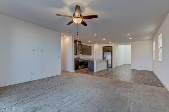 unfurnished living room with recessed lighting, a sink, carpet flooring, baseboards, and a ceiling fan