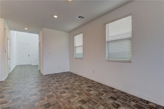 empty room with recessed lighting, visible vents, and baseboards