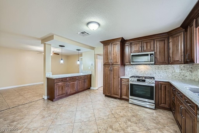 kitchen featuring ceiling fan, visible vents, appliances with stainless steel finishes, decorative backsplash, and decorative light fixtures