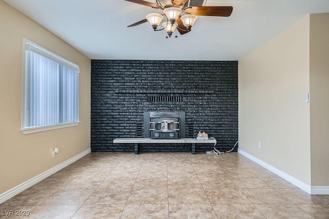 unfurnished living room with a wood stove, tile patterned flooring, baseboards, and ceiling fan