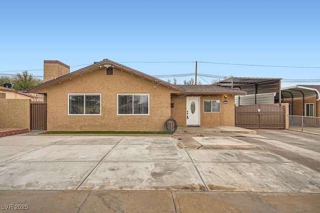 view of front of home featuring fence, a gate, and stucco siding