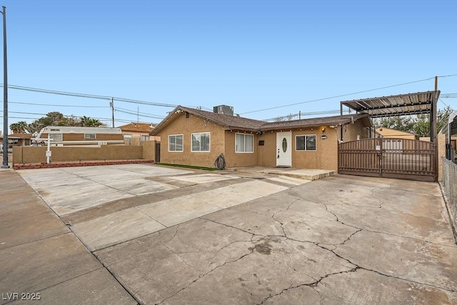 ranch-style house featuring driveway, fence, cooling unit, and stucco siding