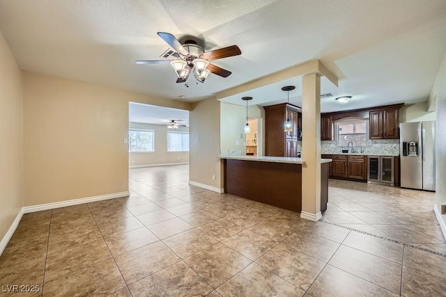 kitchen featuring light tile patterned floors, stainless steel fridge, decorative backsplash, wine cooler, and light countertops