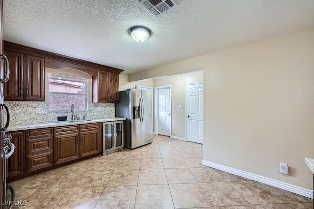 kitchen featuring beverage cooler, visible vents, decorative backsplash, stainless steel fridge with ice dispenser, and a sink