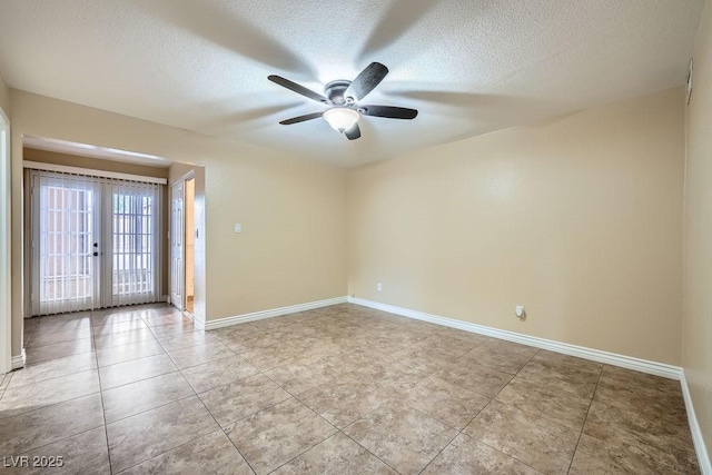 empty room with french doors, a textured ceiling, and baseboards