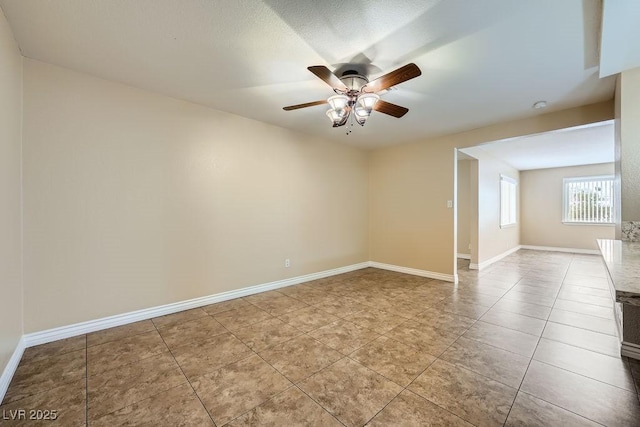 unfurnished room featuring tile patterned flooring, baseboards, and ceiling fan