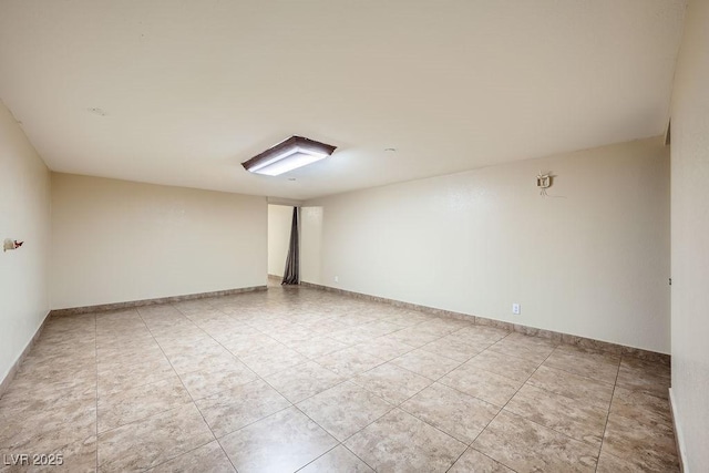 unfurnished room featuring baseboards and light tile patterned floors