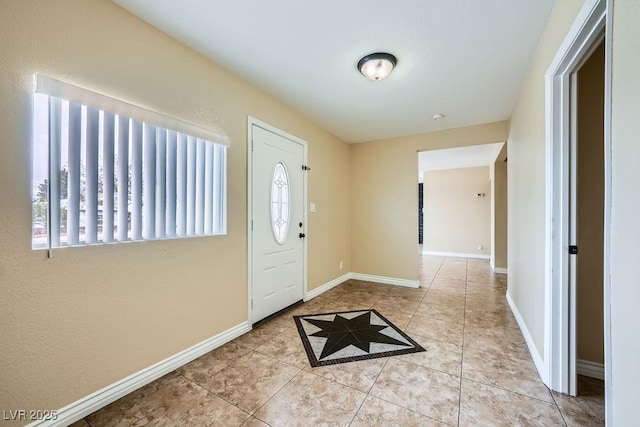 tiled foyer entrance with baseboards and a wealth of natural light