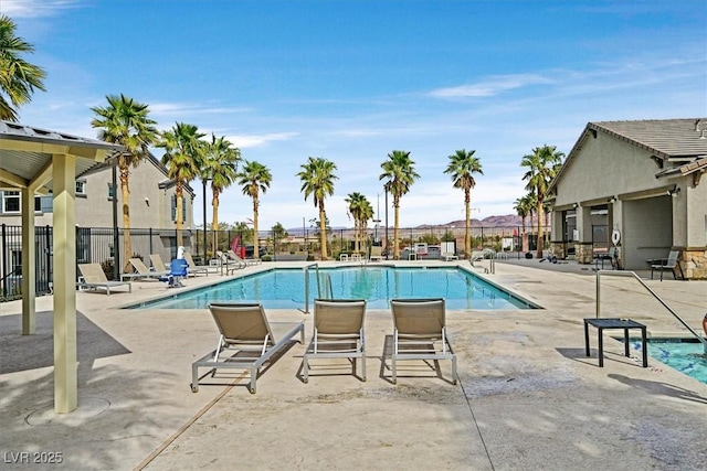 community pool featuring fence and a patio