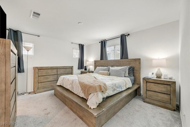 bedroom featuring visible vents and light carpet