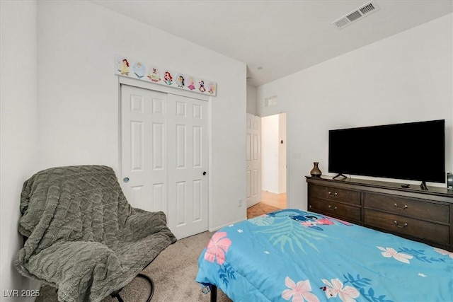 bedroom featuring a closet, visible vents, and light colored carpet