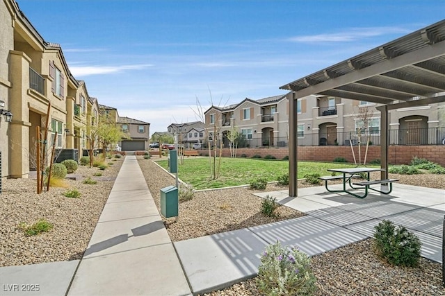 view of home's community featuring a lawn, fence, and a residential view