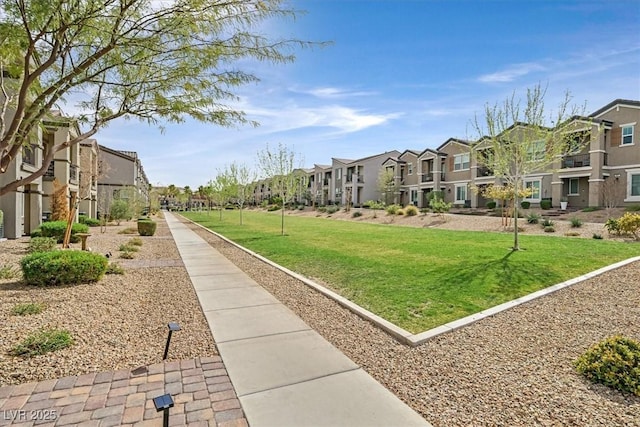 view of property's community with a residential view and a lawn