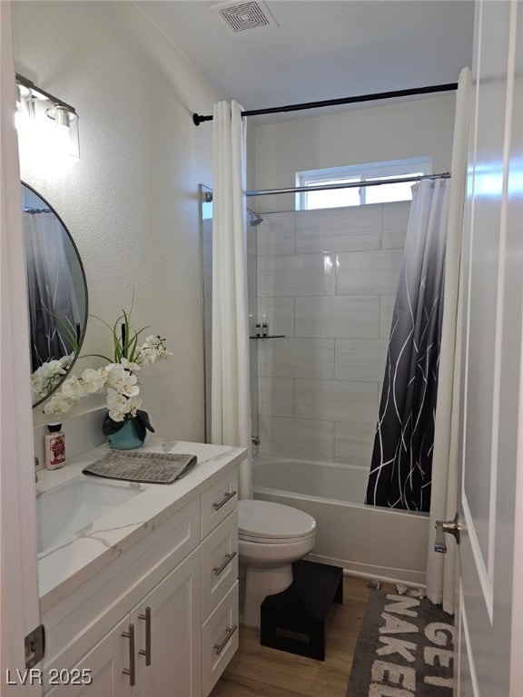 bathroom featuring visible vents, toilet, shower / bath combo, vanity, and wood finished floors