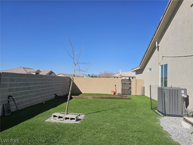 view of yard with a fenced backyard and central AC unit