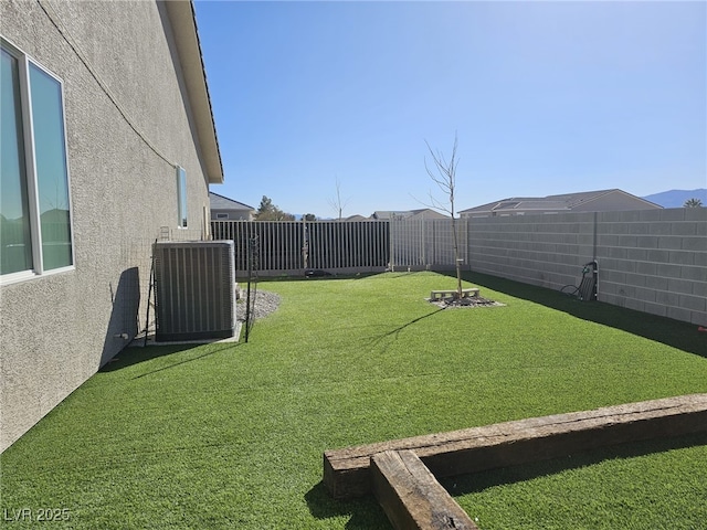 view of yard featuring a fenced backyard and central air condition unit