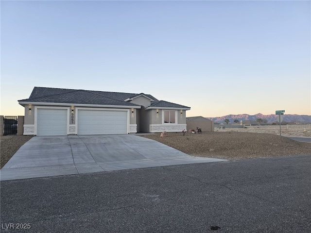 view of front of property featuring an attached garage, concrete driveway, and stucco siding