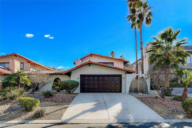 mediterranean / spanish house featuring stucco siding, concrete driveway, and an attached garage