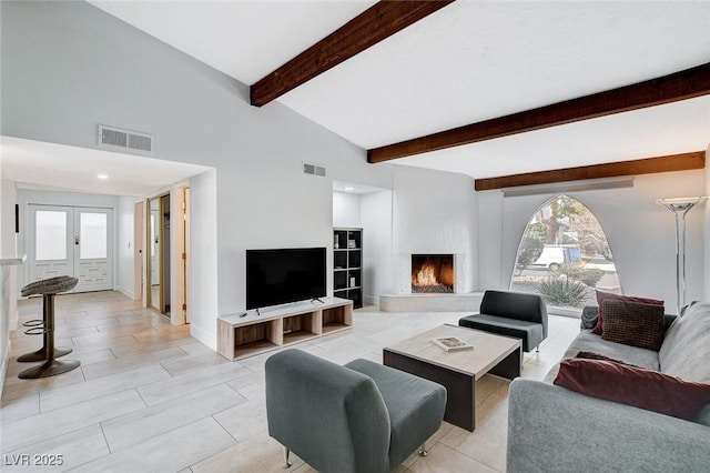 living room featuring beam ceiling, visible vents, french doors, and a large fireplace