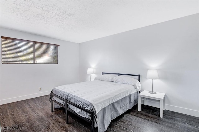 bedroom with dark wood-style flooring, a textured ceiling, and baseboards