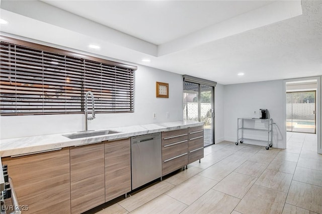 kitchen featuring light stone countertops, dishwasher, a sink, and modern cabinets