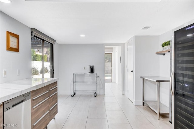 kitchen featuring visible vents, dishwasher, modern cabinets, light stone countertops, and light tile patterned flooring