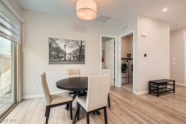 dining space with light wood-style floors, visible vents, and washing machine and clothes dryer