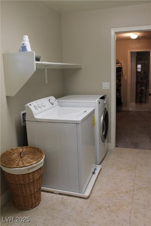 washroom with light tile patterned floors, laundry area, and washer and dryer