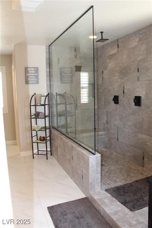 bathroom with a stall shower, marble finish floor, and baseboards