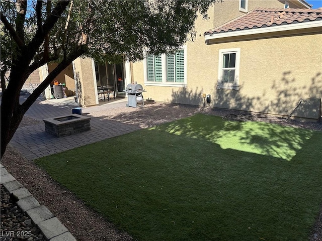 view of yard featuring a fire pit and a patio