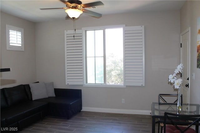 living room with wood tiled floor, ceiling fan, and baseboards