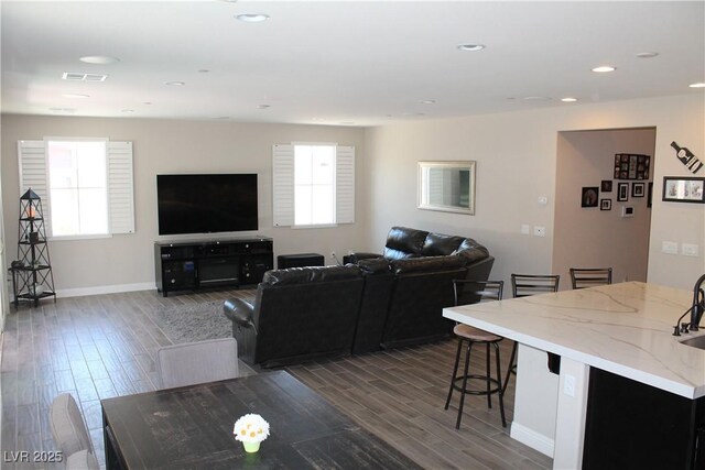 living room featuring a wealth of natural light, visible vents, recessed lighting, and wood finished floors