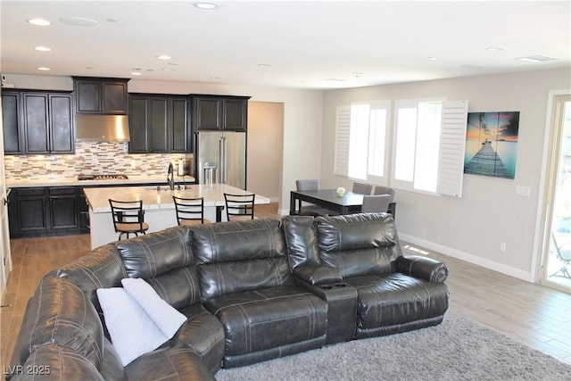 living area with recessed lighting, wood finished floors, and baseboards