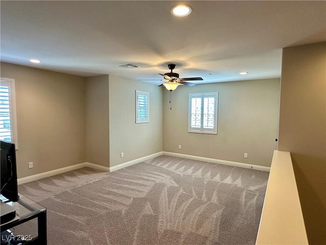 unfurnished room featuring light carpet and baseboards