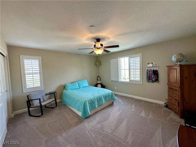 carpeted bedroom featuring a closet, ceiling fan, and baseboards