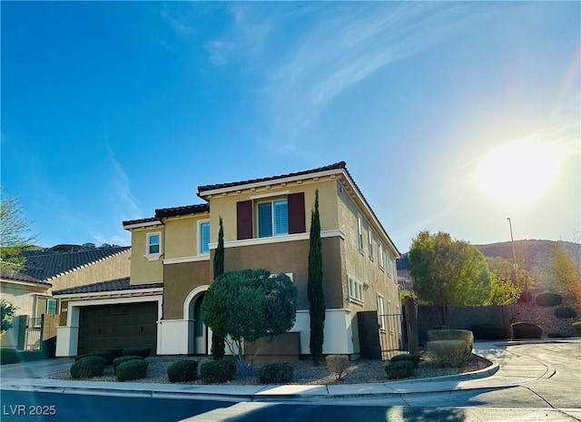 view of front of house featuring driveway, fence, and stucco siding