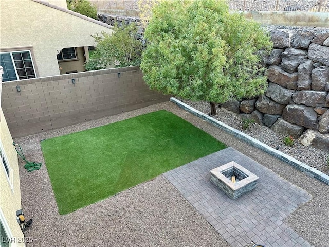 view of yard featuring a patio, an outdoor fire pit, and a fenced backyard