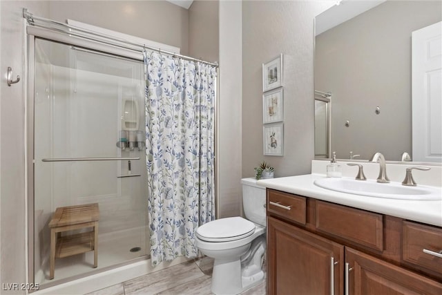 full bath with toilet, a shower stall, and vanity