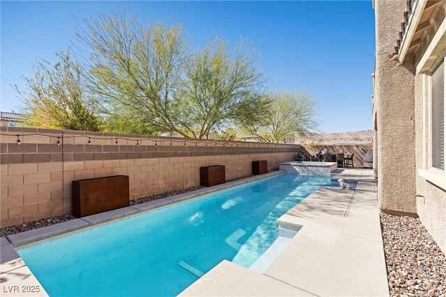 view of swimming pool featuring a pool with connected hot tub, a fenced backyard, and a patio