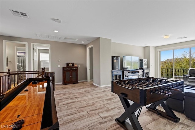 recreation room featuring light wood-style floors, visible vents, and baseboards