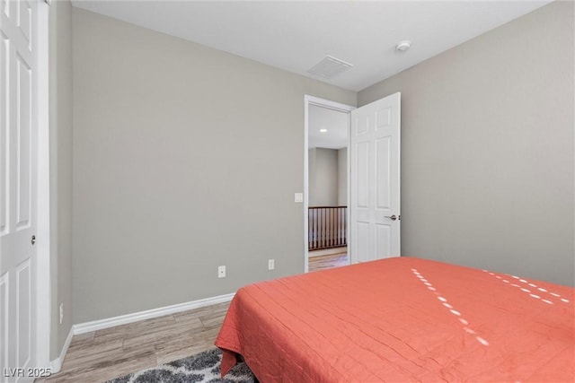 bedroom with baseboards and wood finished floors